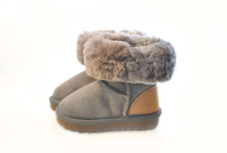 Kids warm winter boots in gray fur with a lapel.