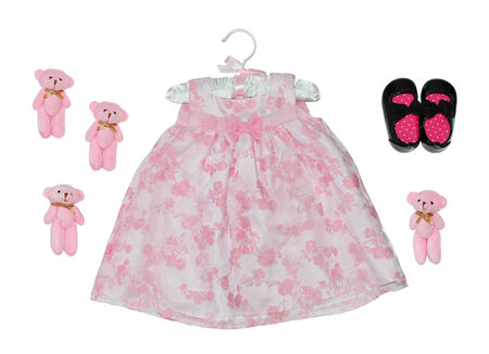 Children's fancy pink dress isolated on white near shoes and toys.の写真素材