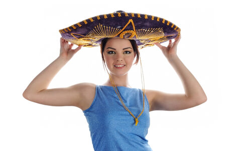 Young smiling girl trying on Mexican sombrero. Portrait on white backgroundの写真素材