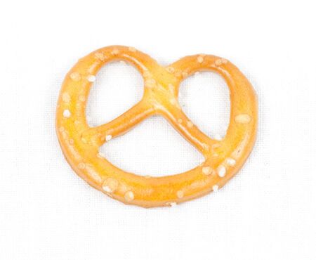Crunchy snacky pretzel with salt on white canvas