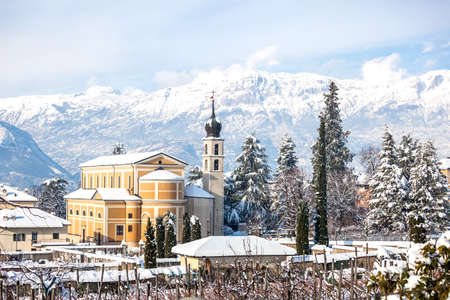 Beautiful winter landscape with church and Alps in Trento, the Northern Italy.の写真素材