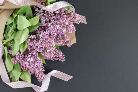 Postcard for Mother's Day, March 8, Valentine's Day. Lilac bouquet with pink satin ribbon. Place for your text. Layout. Horizontal photo.の写真素材