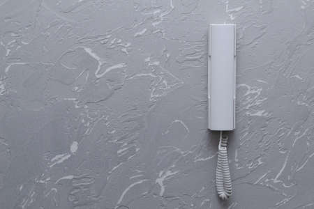 The home security system is white. White communication tube from the intercom locking device on the gray concrete wall in the apartment.の写真素材