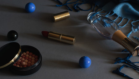 A set of decorative cosmetics for face makeup. On a dark background, blush in balls, red lipstick, women's perfume.の写真素材