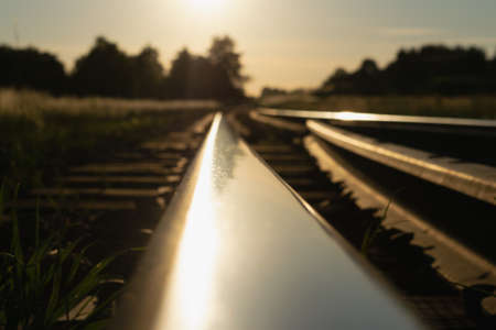 Bright colorful summer sunset over the railroad. Horizontal photo. Selective focus.の写真素材
