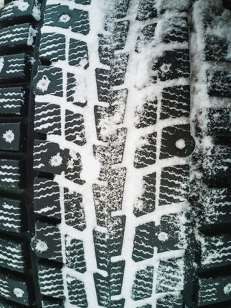 Winter tires with spikes for off-road vehicles. Vertical photo.