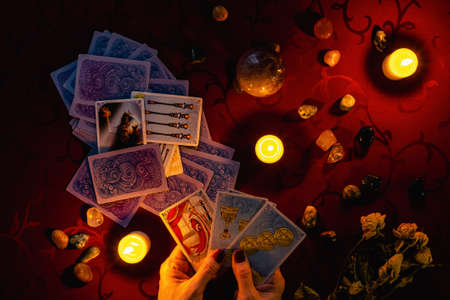 MINSK, BELARUS - November 2021: A fortune teller reads tarot cards and holds cards in her hand. Magic and occultism.のeditorial素材