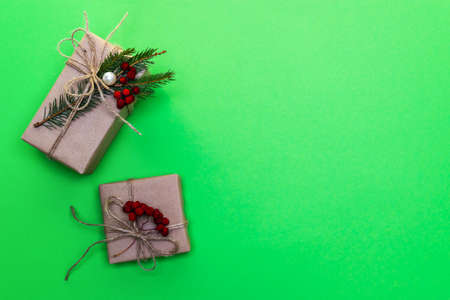 On a green background gifts with spruce twigs and rowan berries. A Christmas gift. Horizontal photo.