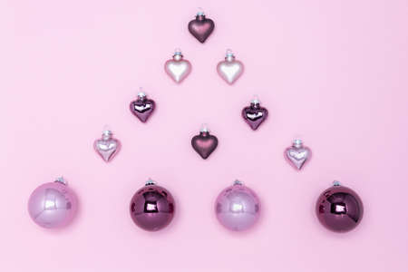 Christmas tree decorations on a pink background, laid out in the form of a fir. Lilac and purple balloons and hearts. Christmas card.の写真素材
