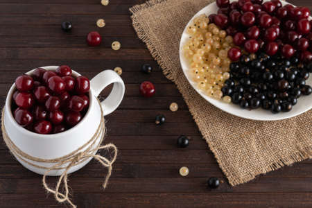 Assorted berries of cherries, white and black currants are on a wooden table. horizontal photo.の写真素材