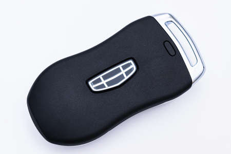 Minsk, Belarus - February 2022: Close-up of a black smart key from a Geely Tugella car on a white background. Electronics, spare parts and car accessories. horizontal photo.のeditorial素材
