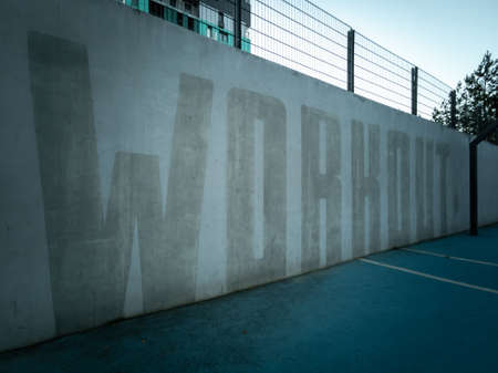 outdoor sports ground. Workout inscription on a concrete wall. horizontal photo.