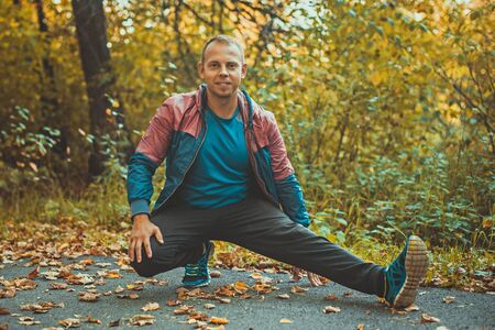 sport man stretching at the park autumn, doing exercises. Fitness conceptsの写真素材