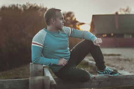 Attractive man sitting on beach in the evening  after sportの写真素材