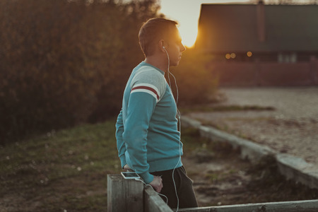 Attractive man sitting on  beach in the evening sunset after sport.