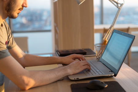 young man working with laptop, view of hands on notebook , business person at workplace.の写真素材