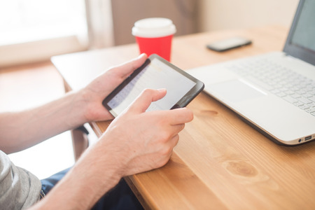 Workplace. Hands holding tablet and notebook closeup.