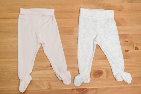 Clothes for newborn girl on a wooden background.の写真素材
