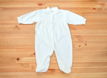 Clothes for newborn girl on a wooden backgroundの写真素材