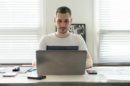 Young business man working on a laptop at his desk in the office.の写真素材