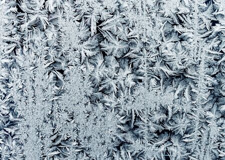 winding rows of frost of ice crystals on winter glass