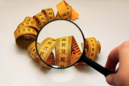 the magnifying glass aimed at measuring tapeの写真素材