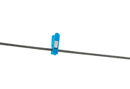 blue plastic clothespin hanging on rope on white isolated backgroundの写真素材