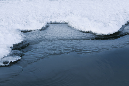  water's edge covered with a white brilliant blue ice on a freezing lakeの写真素材