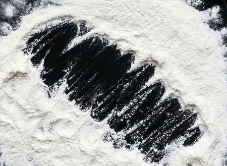 background for recording of crumbly white wheat flour on the black tableの写真素材