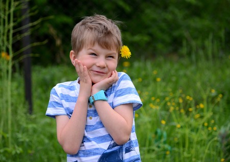 boy with a dandelion in his hair laughing