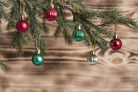 spruce branch with red and green balls on wooden backgroundの写真素材