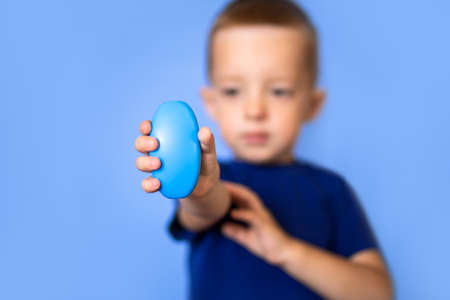 Baby holds soap, focus on soap.の写真素材