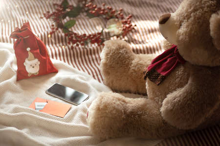 A big soft toy teddy bear orders a gift online through a smartphone, humor.