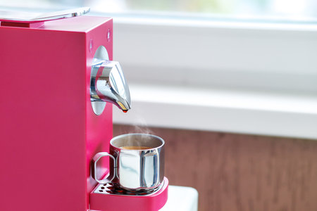 Morning Expresso in a metal cup of capsule coffee machine.の写真素材