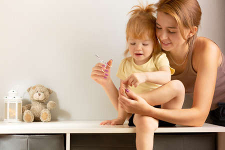 Mom trims her daughters nails, concept childcare.の写真素材
