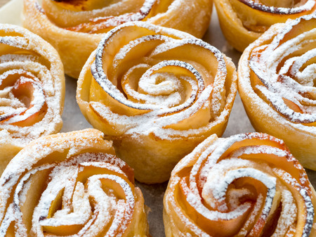 homemade pastries of flaky unleavened dough with apples on parchment paperの写真素材