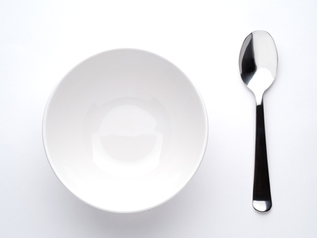deep soup plate and spoon on white background, top viewの写真素材