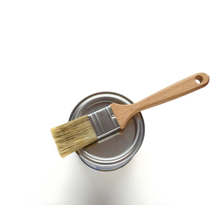 White paint with paint brush on metall container over white backgroundの写真素材
