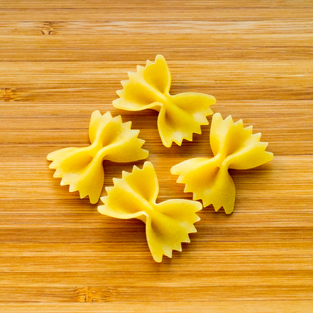 Four butterflies  for italian pasta on wood background. Dietary food of carbohydratesの写真素材