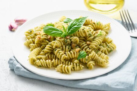fusili pasta with basil pesto and herbs, italian cuisine, gray stone background, closeupの写真素材