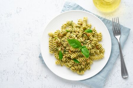 fusili pasta with basil pesto and herbs, italian cuisine, gray stone background, top viewの写真素材