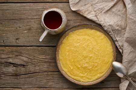 porridge polenta with cup of tea, dark wood background, top viewの写真素材