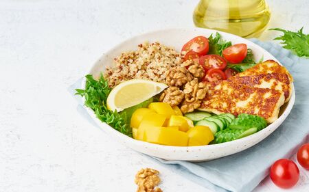 Buddha bowl with halloumi, salad lettuce, quinoa, vegetarian menu, white background, closeup with copy spaceの写真素材