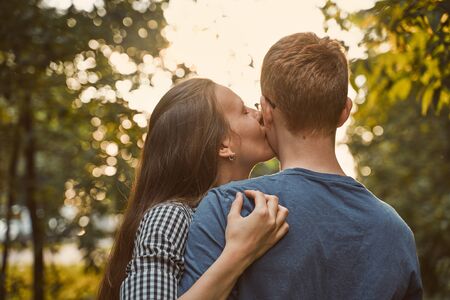 boyfriend and girlfriend closeup, embracing and kissing in a cheekの写真素材