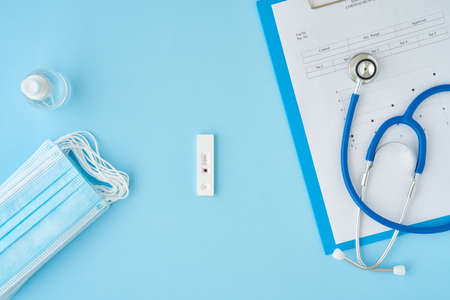 Positive test for antibodies to covid-19 virus. Bright blue table, medical mask, express test for...