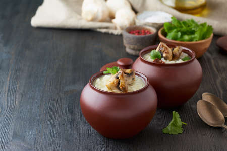Unconventional unusual serving of risotto with mushrooms in pot. Rice porridge with mushrooms....