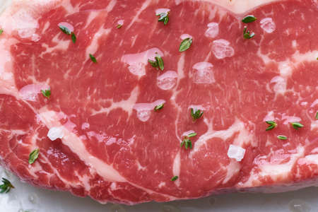 Big whole piece of raw beef meat, striploin. Steak with seasoning, close up, macroの写真素材