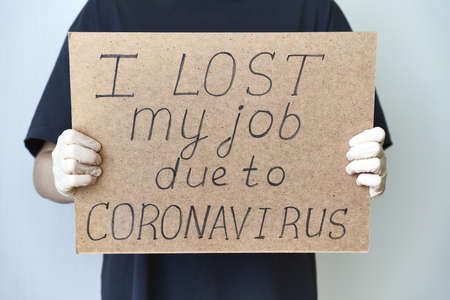 Job loss due to COVID-19 virus pandemic concept. Unrecognizable person holds sign I lost my jobの写真素材