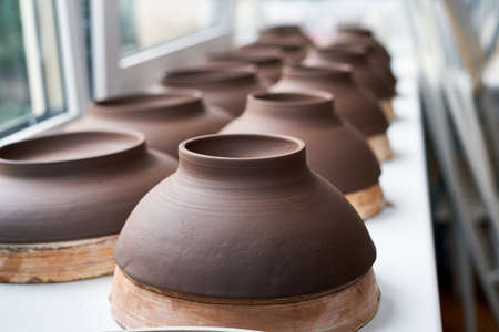Manufacture of ceramic products, workpiece. Close up background with ceramic pieces of ware against windowの写真素材