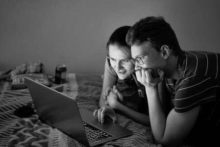 Two teenagers watching film during quarantine due to coronavirus pandemic. Boy and girlの写真素材